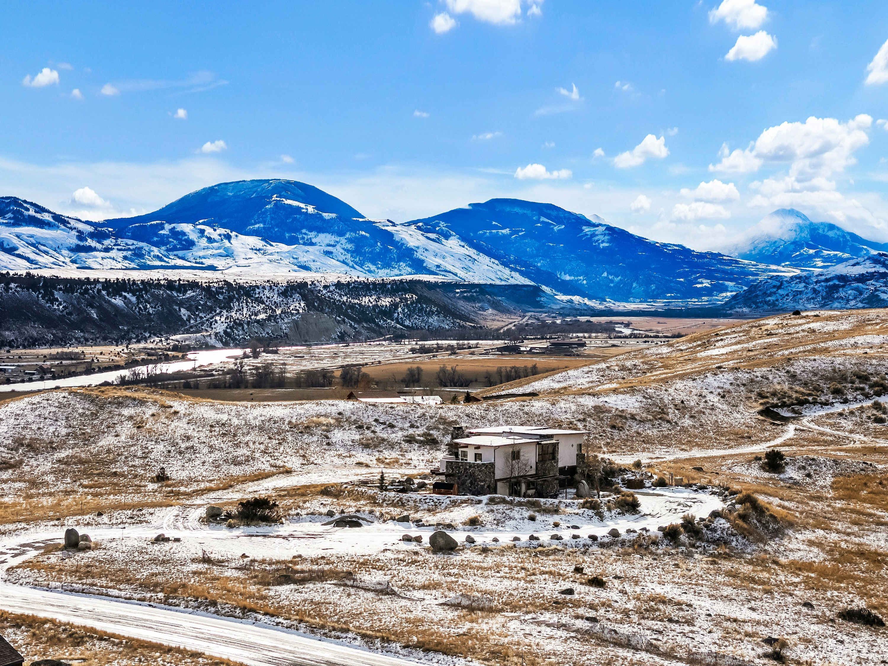 A remote mountain landscape with a small building in the foreground.