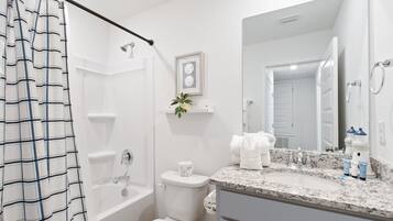 A bathroom with a bathtub, toilet, and sink.