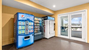 Myyntialue, jossa on Pepsi-automaatti ja jääautomaatti, sekä lasiovet, jotka johtavat ulkona olevalle oleskelualueelle.