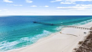 Ein Strand mit einem Steg, der sich ins Meer erstreckt.