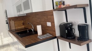 A modern kitchen with a wooden countertop, a sink, a coffee maker, and a Bosch appliance. - New house or town center + parking space (Dijon)