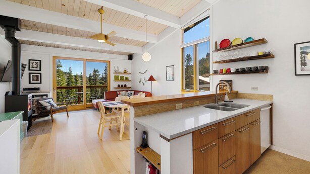 Una cocina moderna con armarios de madera, una isla grande y vistas al exterior.