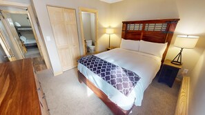 A bedroom with a wooden headboard, a bed with patterned bedding, two bedside lamps, and a wooden dresser. - Updated! Walk to Main St. Events, Dining, Shops. 1st Floor, Pool, Hot Tub (Frisco)