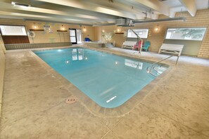 An indoor swimming pool with a tiled floor, a changing room with a shower, and a seating area with chairs. - Updated! Walk to Main St. Events, Dining, Shops. 1st Floor, Pool, Hot Tub (Frisco)