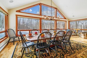 Bright Dining Room - Floor-to-ceiling windows fill the dining area with natural light and showcase the peaceful mountain setting. - 3 bedroom pet-friendly Killington retreat with fireplace and room for 8. (Killington)