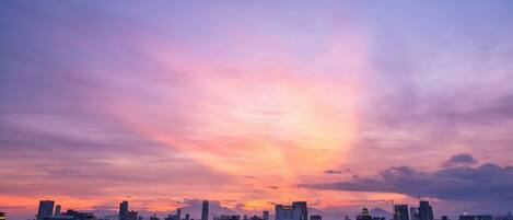 A cityscape at dusk with buildings and a sunset.