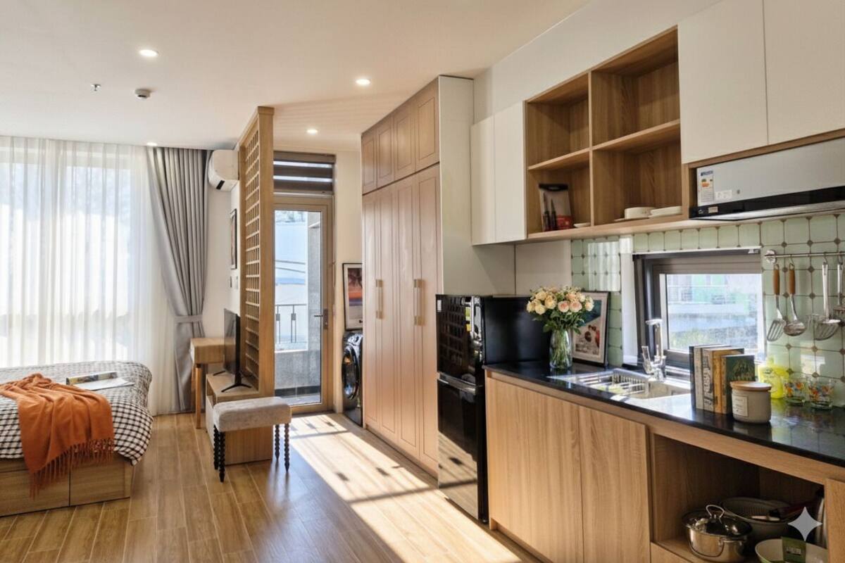 A modern kitchen with wooden cabinets, a black refrigerator, and a window with a view.