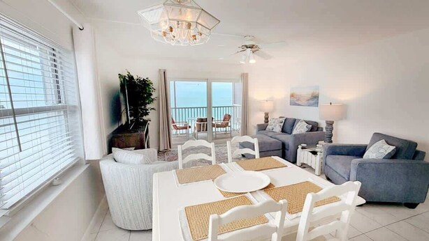 Un salon moderne avec une table à manger, des canapés et un balcon offrant une vue agréable.