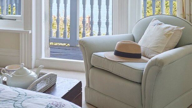 A room with a view of the sea, a balcony with a railing, and a chair with a hat. - West Ingle Large Edwardian Home Overlooking Seagrove Bay (Seaview)