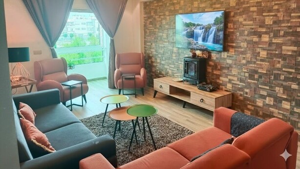 A modern living room with a fireplace, a television, and comfortable seating. - Résidence Luxueuse, 2 Piscines Escapade Familiale à 2 pas Plages Harhoura Rabat (Harhoura)