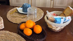 Eine Küche mit Mikrowelle, Toaster und Kaffeemaschine. Auf dem Tisch liegen Orangen und Brot.