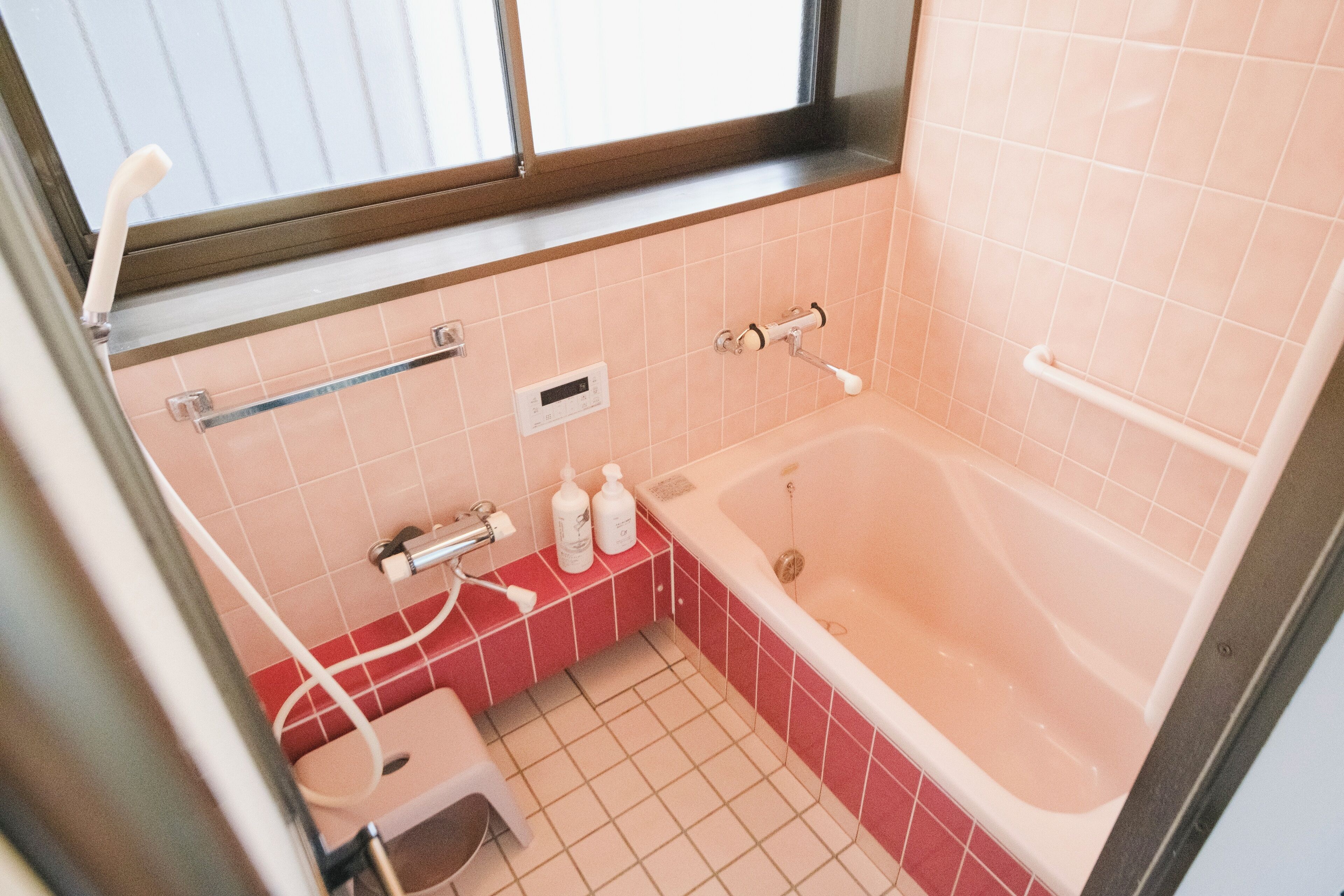 A bathroom with a bathtub, a toilet, and a shower area.