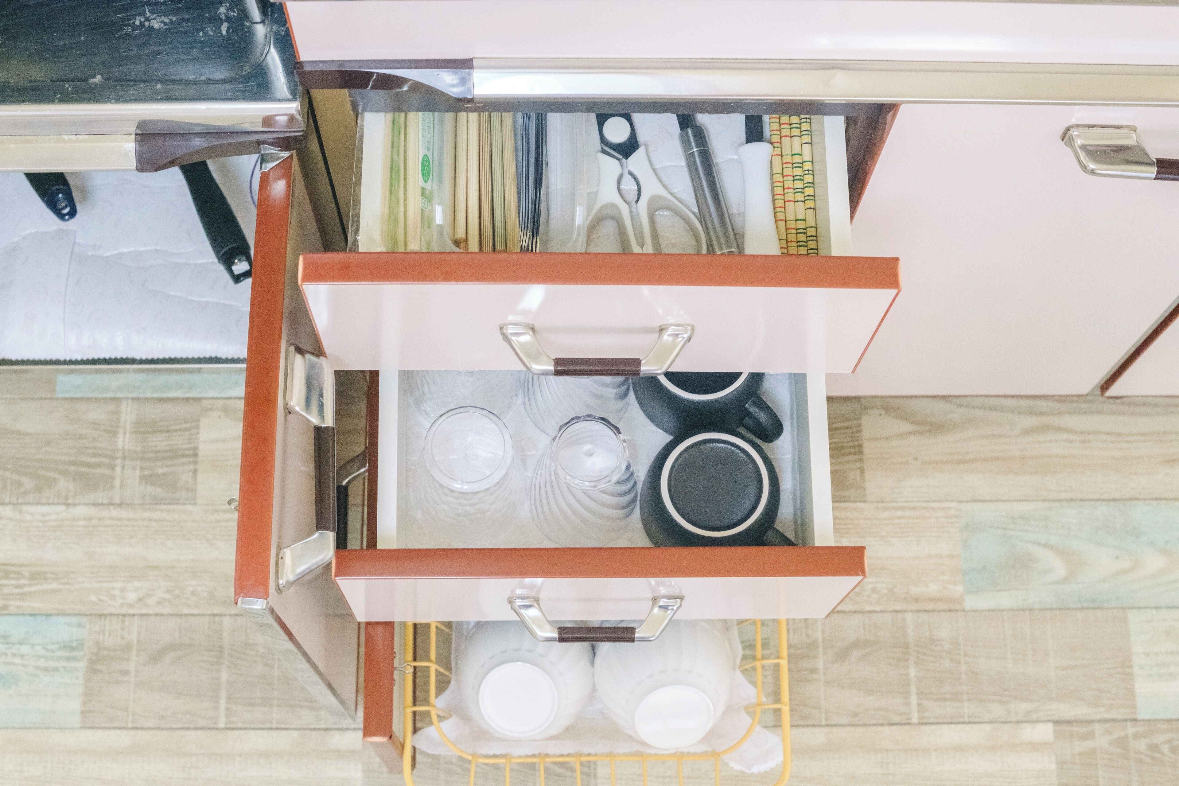 A kitchen drawer with utensils, cookware, and glassware.