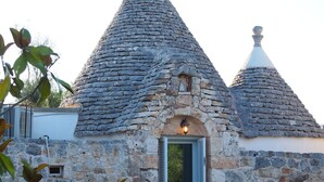 Un edificio de piedra con techo cónico y una puerta.