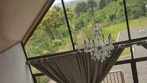 Una habitación con un ventanal grande, una bañera de hidromasaje y un candelabro.