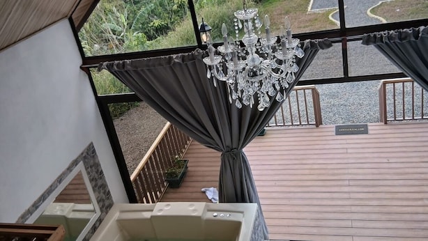 Un área de spa con jacuzzi, una araña y vistas a un estacionamiento y follaje exterior.