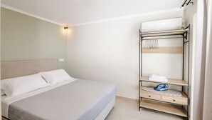 A bedroom with a bed, a wardrobe, and a ceiling light. - Restia tower apartments (Zakynthos)