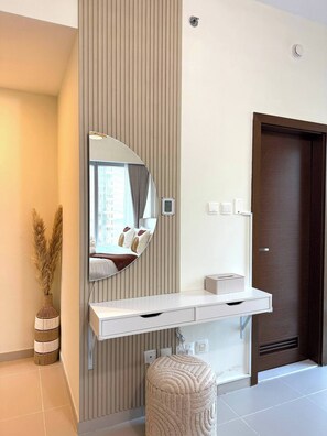 A modern bathroom with a large mirror, a towel rack, and a small shelf. - High-Floor 2BR + Maid  Sleeps 9 Pool View Reem Island (Abu Dhabi)