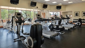Un gimnasio con cintas de correr, elípticas y máquinas de pesas.