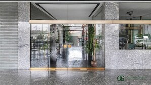 A modern lobby with a glass partition, granite columns, and a reflection of the outside. - Greco Heritage Suite in Milan (Milan)
