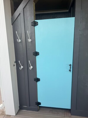 A door with a black frame and a light blue door panel, featuring multiple silver handles and black hinges. - Elegant Oceanfront 4 Bedroom 4 Bathroom 14 person home with direct, private beach access and panoramic beach views. (Ocean Isle Beach)