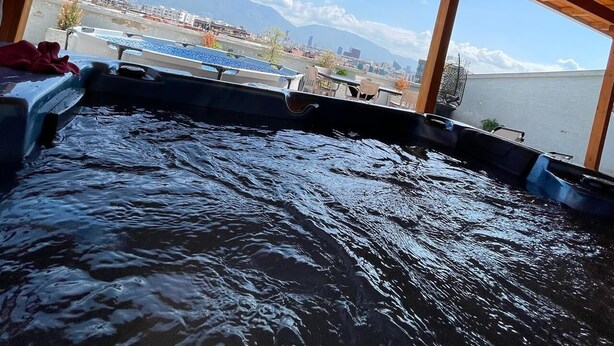 Een houten terras met uitzicht op een waterpartij en verre bergen.