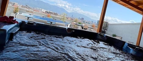 A wooden deck with a view of a body of water and distant mountains.