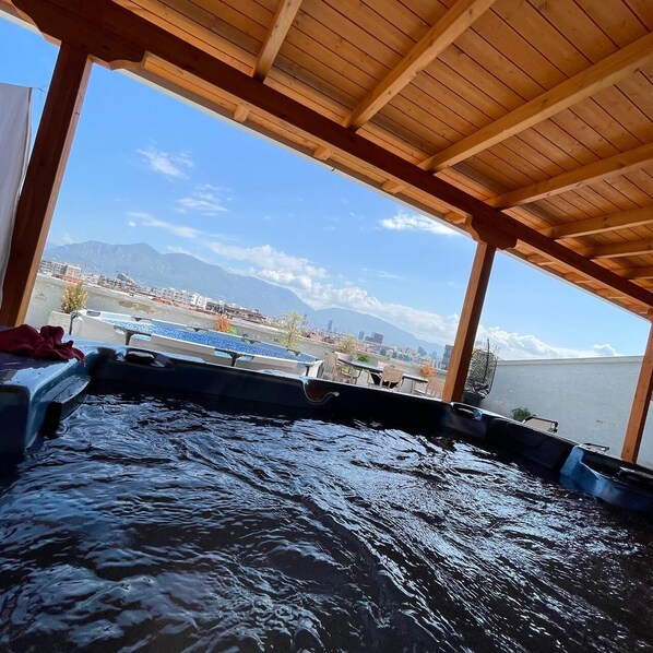 A wooden deck with a view of a body of water and distant mountains. - Exclusive 5BR Rooftop: 2 Hot Tubs, Plunge Pool & Stunning Tirana Views (Kashar)