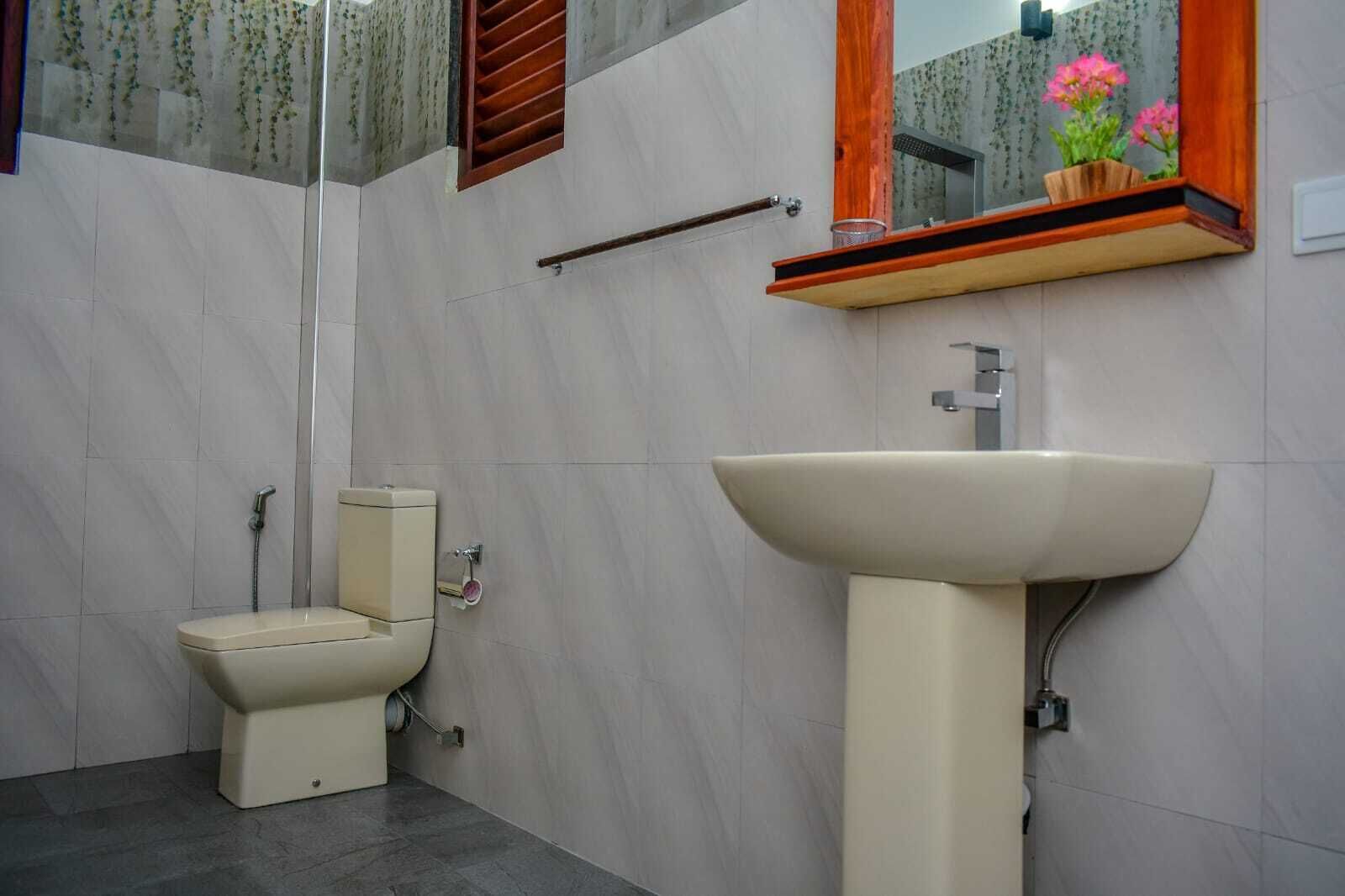 Une salle de bain avec des toilettes, un lavabo et un miroir.