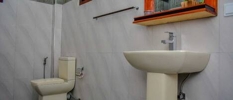 A bathroom with a toilet, a sink, and a mirror.