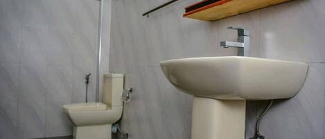Un baño con inodoro, lavamanos y espejo.