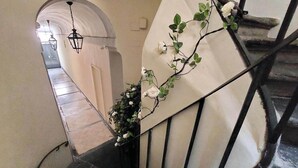A spiral staircase with a white wall and a black metal railing. - Flatinrome Spagna Spanish Steps (ROMA)