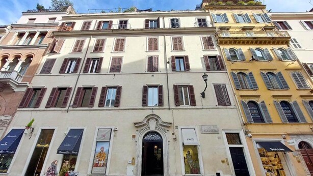 A multi-story building with a classic European architectural style, featuring a central entrance with an ornate archway. - Flatinrome Spagna Spanish Steps (ROMA)