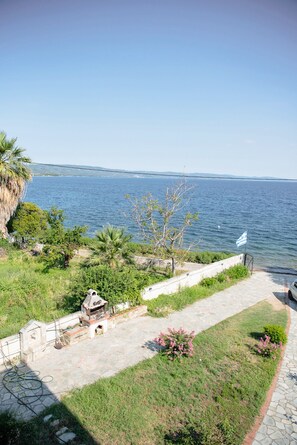 Une terrasse avec un barbecue, un drapeau et une vue sur la mer.