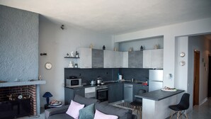 Una cocina moderna con gabinetes grises, horno empotrado y una isla central.