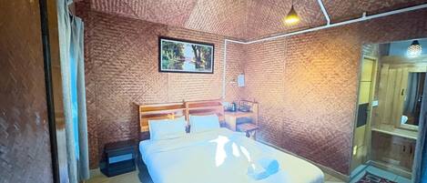 Een slaapkamer met een bed, een plafondventilator en een aan de muur bevestigde televisie.