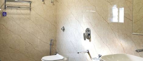 A modern bathroom with a toilet, bidet, and two sinks.