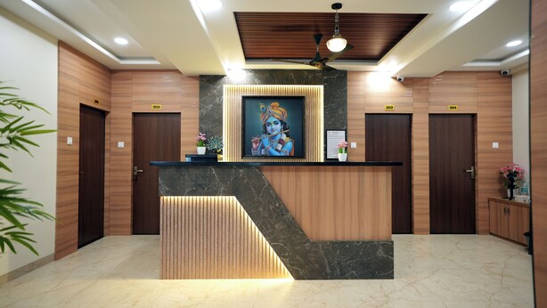 A reception desk with a framed artwork, wooden paneling, and a ceiling fan. - HOTEL CITY INN (Nagpur)