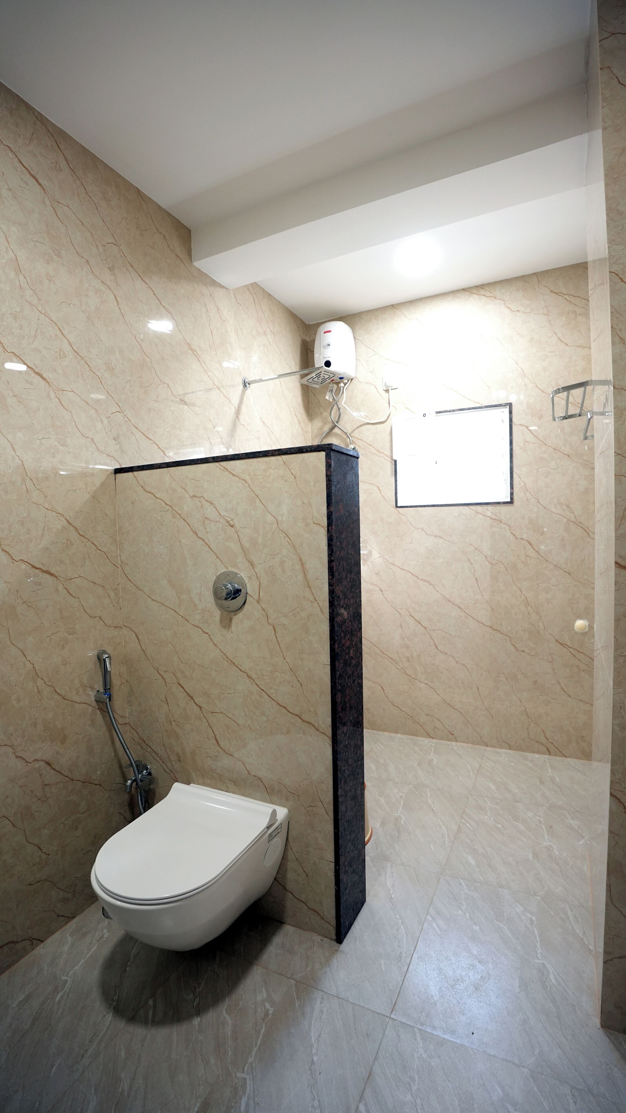 A modern bathroom with a freestanding toilet, a shower area, and a marble-tiled floor.