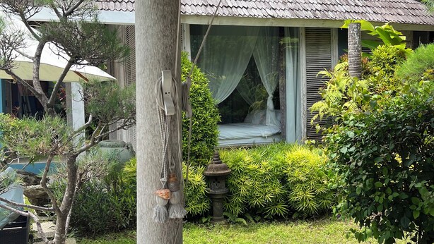 A traditional house with a tiled roof, a garden with various plants, a stone lantern, and a small tree in a pot. - Villa Green Haven - Canggu - private Balinese villa with pool (Canggu)