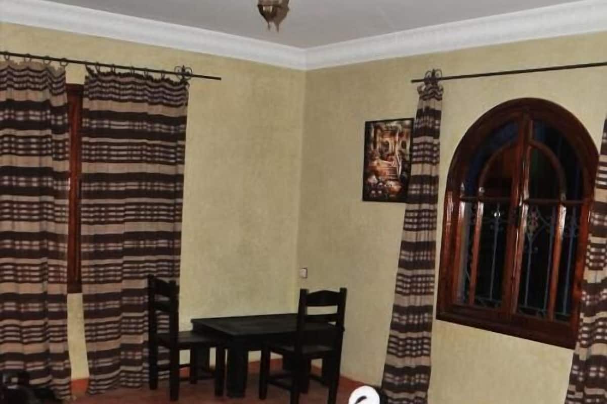 A bedroom with a bed, a desk, and a chair.