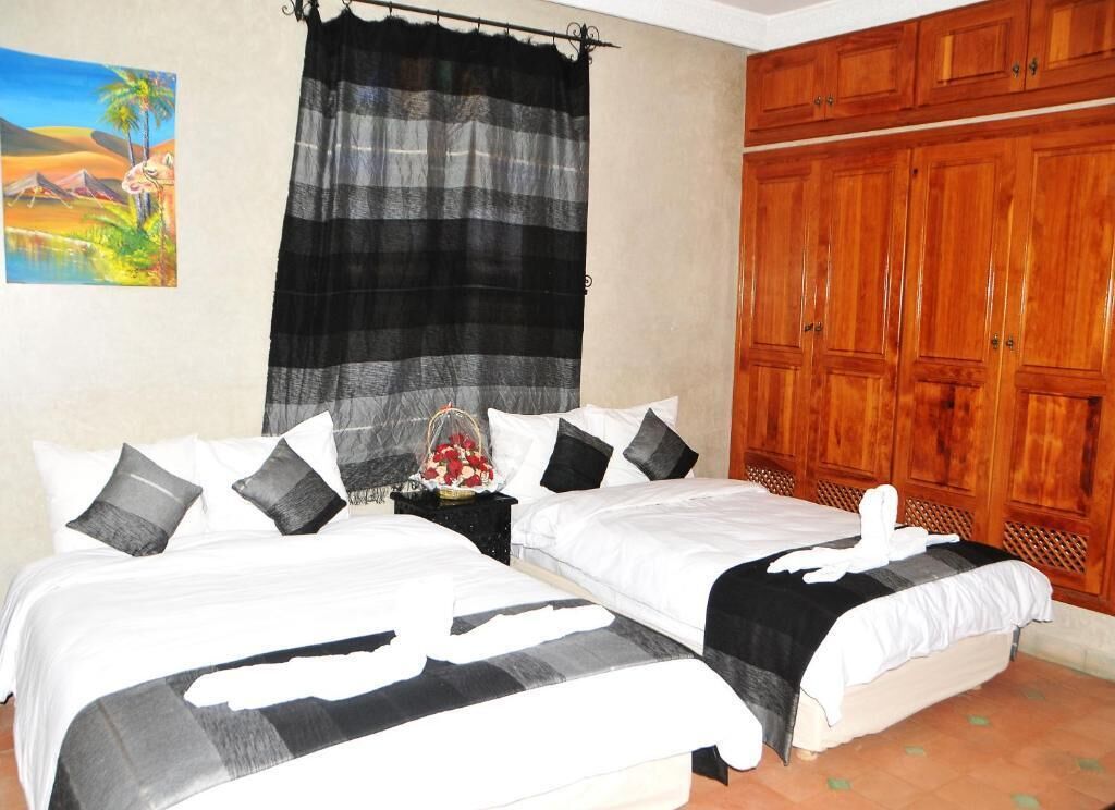 Un dormitorio con dos camas, un armario de madera y un cuadro en la pared.