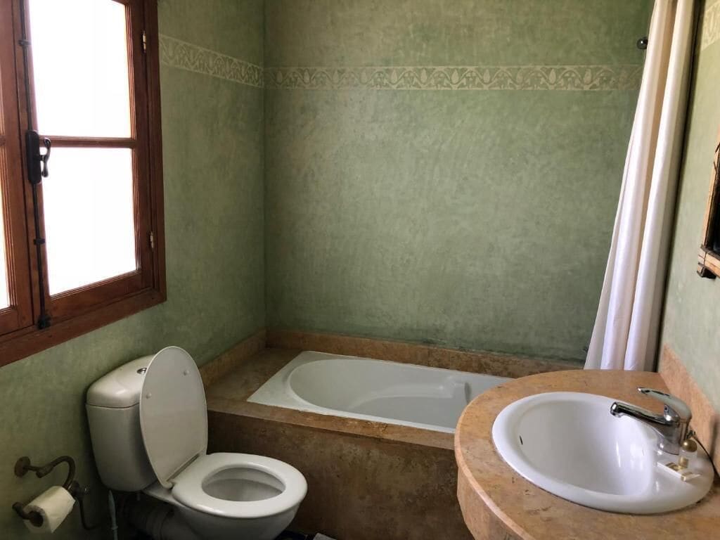 A bathroom with a toilet, bathtub, and sink.