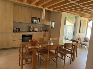 A modern kitchen with wooden cabinets, a dining table with chairs, and a view of the outdoors. - Exceptional property, 3 suites—50 m from the beach. Entire property: Villa Hyères, France (Hyères)