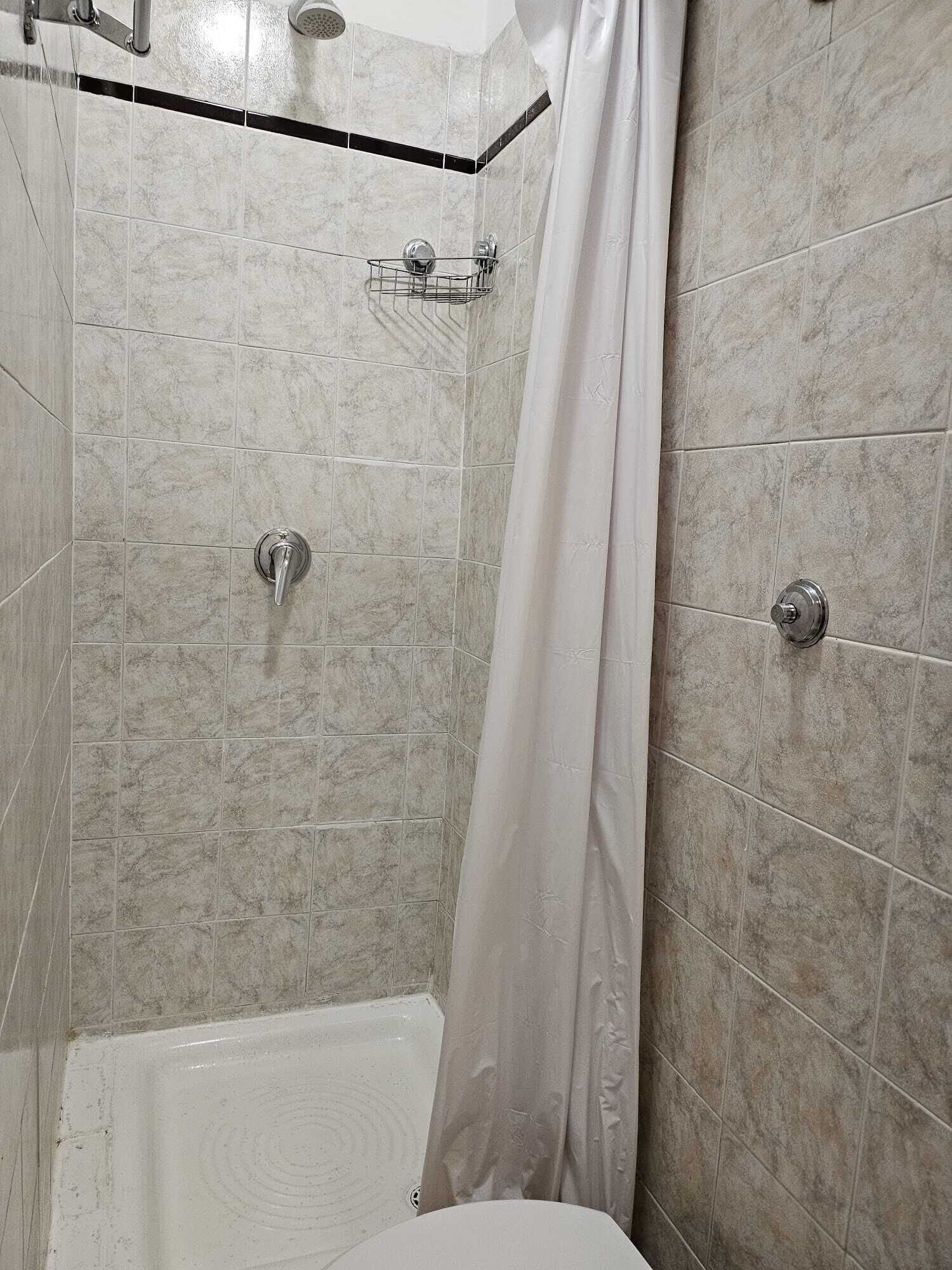 A bathroom with a shower, a bathtub, and a toilet.