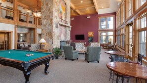 A spacious indoor area with a pool table, comfortable seating, and large windows. - Grand Timber Lodge Studio, Hot Tubs, Pools & Sauna, map location is not correct (Breckenridge)