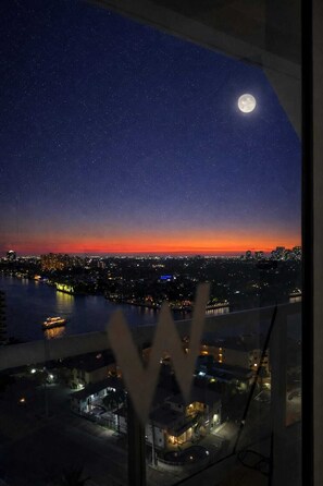 A night view of a cityscape with a visible moon and a river. - Coastal View Retreat-W Hotel Condo (Fort Lauderdale)