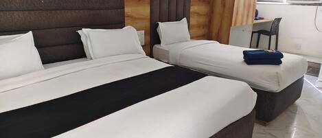 Een hotelkamer met twee bedden, een houten hoofdbord, een bureau en een stoel.