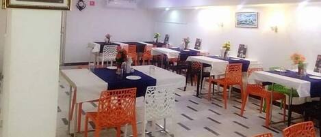 Un comedor con mesas y sillas, unidades de aire acondicionado e iluminación empotrada en la pared.