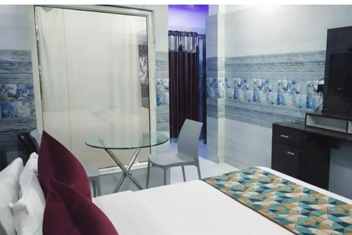Ein Hotelzimmer mit Bett, Schreibtisch, Stuhl, Fernseher und Fenster mit Blick.